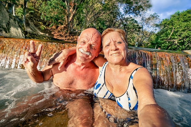 Senior happy couple taking selfie at Maquinit Hot Spring in Coron Philippines