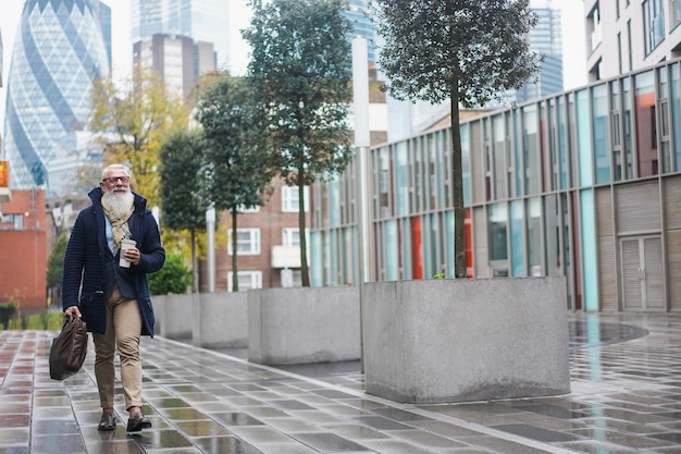 Senior hipster business man walking to work on the city