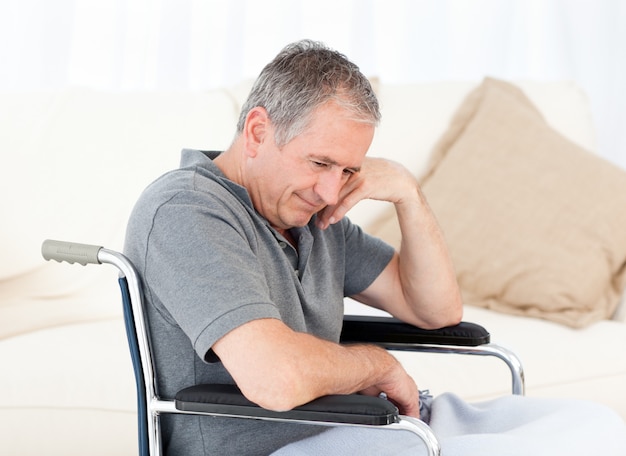 Senior in his wheelchair having a headache