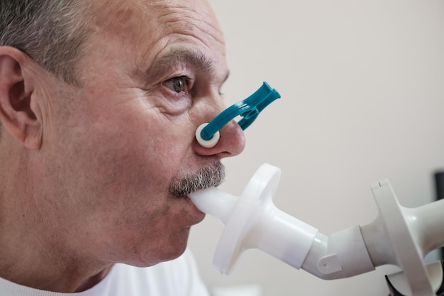 Photo senior hispanic man man testing breathing function by spirometry