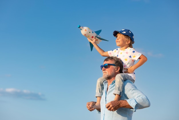 Senior man and child outdoor against summer sky background Grandfather and boy having fun together Family holiday concept Happy Fathers day