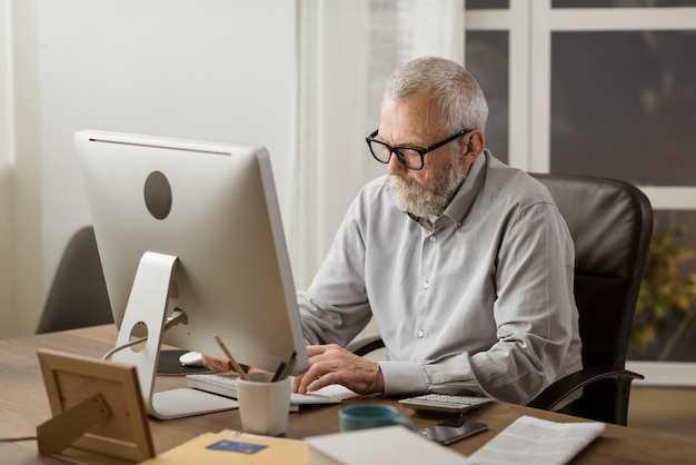 Senior man connecting with his computer at home