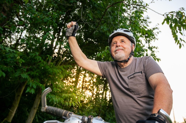 Senior man enjoying lovely bike or cycling in the forest during lovely summer sunset healthy lifesty...