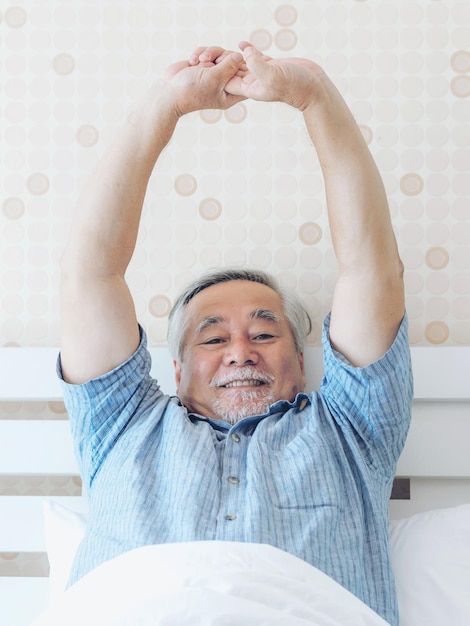 Senior man feel happy good health wake up in the morning enjoying time in his home indoor bedroom background lifestyle senior happiness concept