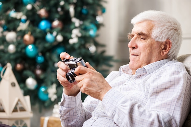 Senior man looking at retro style camera