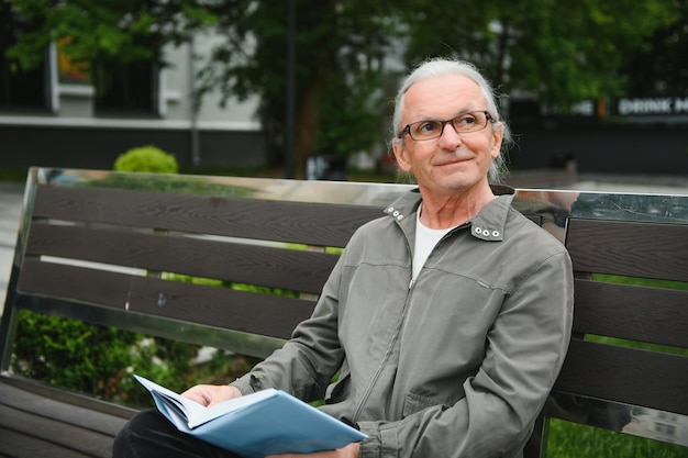 Senior man reading a book in the park