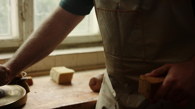 Senior man showing pottery craft master class in workshop Closeup serious artist teaching woman in studio Focused ceramist giving recommendations to woman in pottery