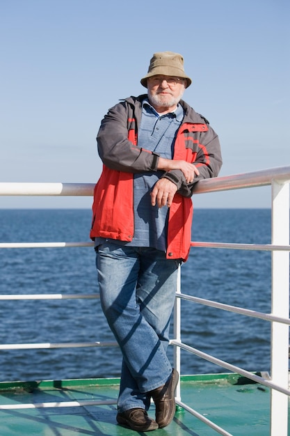 Senior man standing on ship deck