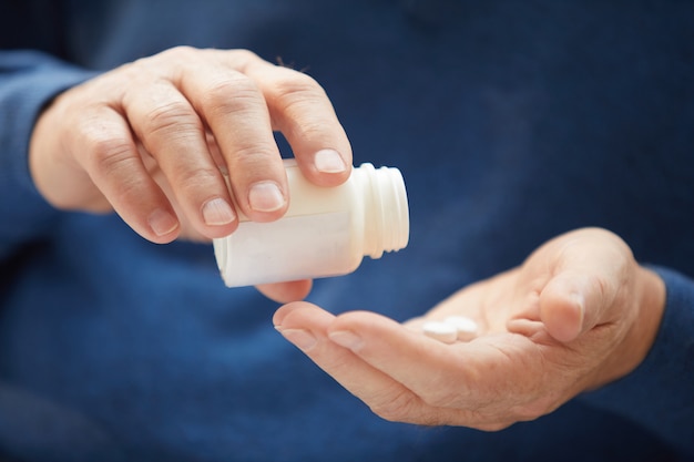 Senior Man Taking Vitamins Closeup