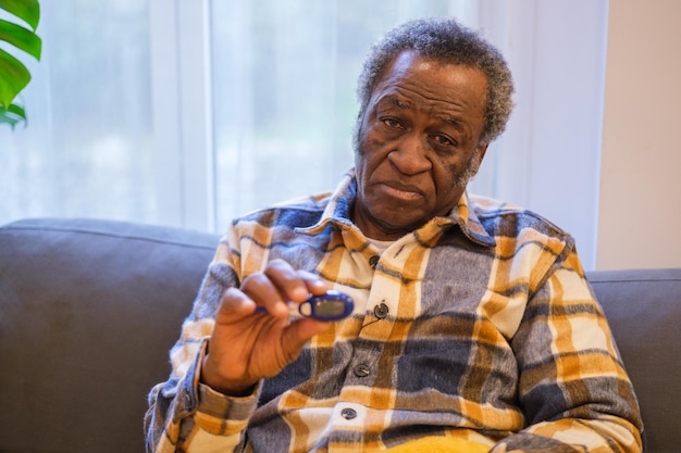 Senior man with gray hair and sick face with thermometer in hand signaling that he has a fever Concept Health Health Care Retiree