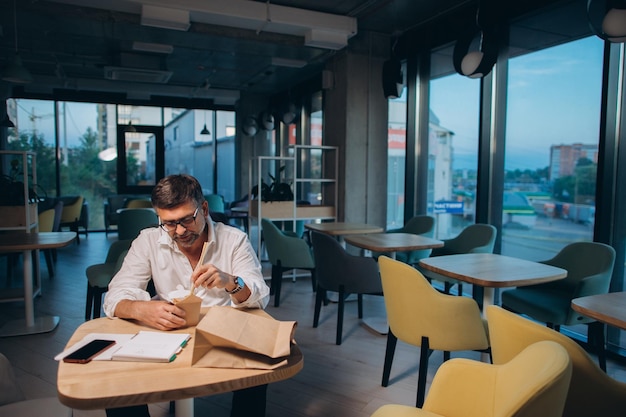 A senior manager orders street food to the office Dinner in the office overtime work conceptxA