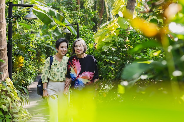 Senior mother and daughter smiling standing in the garden on vacation