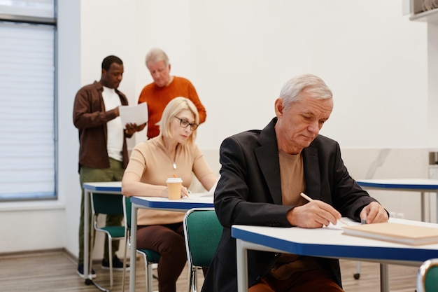 Senior people writing test at classroom