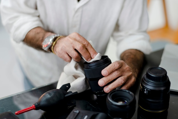 Senior photographer cleaning his lens