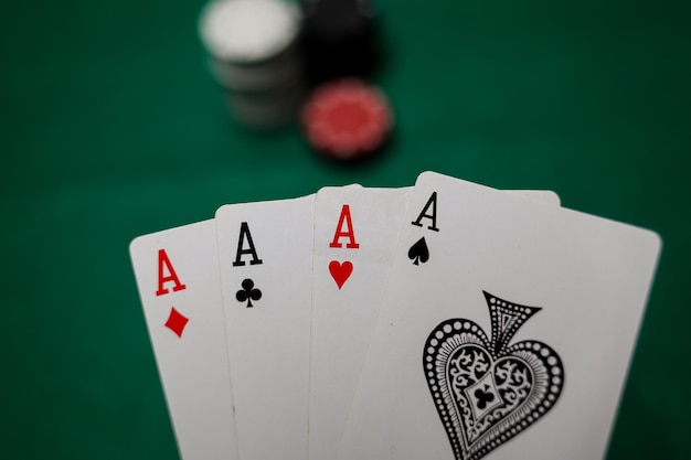 Senior Poker. Four playing cards, four aces and poker chips on a green casino table.