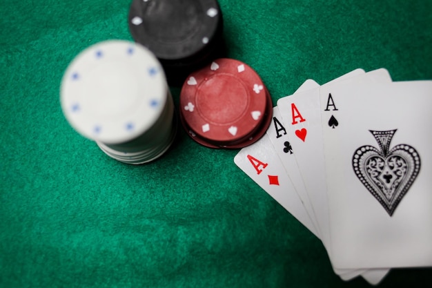 Senior Poker. Four playing cards, four aces and poker chips on a green casino table.