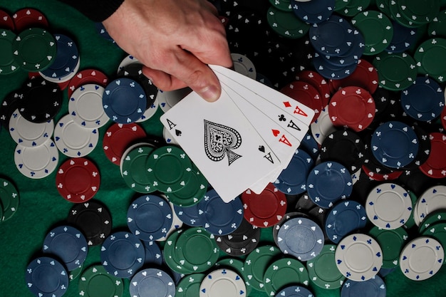 Senior Poker. The player holds in his hand four playing cards, four aces. Casino chips background