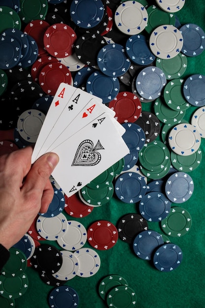 Senior Poker. The player holds in his hand four playing cards, four aces. Casino chips background