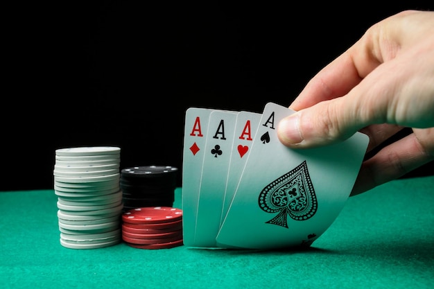 Senior Poker. The player holds in his hand four playing cards, four aces. Casino tabke background