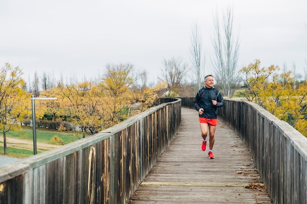 Senior retired man runs and performs exercise