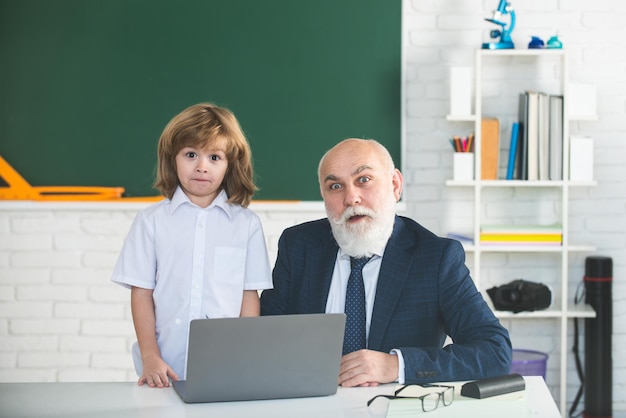 Senior teacher and kid pupil in classroom. Education concept. School learning concept. Boy elementary school.