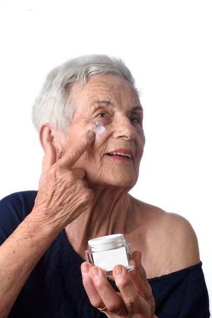 Senior woman applying skin cream or moisturiser to her face