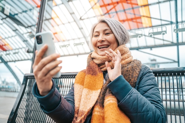 Senior woman are speaking with friends via smartphone