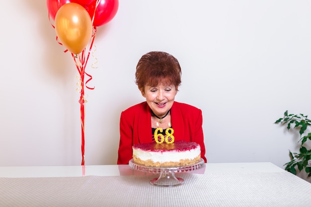 Senior woman blowing out candles on cake