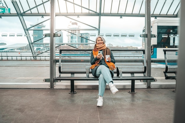 Senior woman buys the train ticket with mobile smartphone app