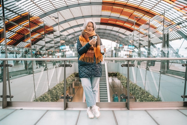 Senior woman buys the train ticket with th smartphone