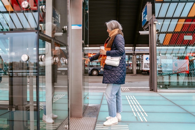 Senior woman buys the train tickets with the automatic machine