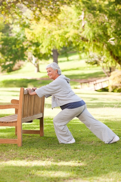 Senior woman doing her stretches in the park