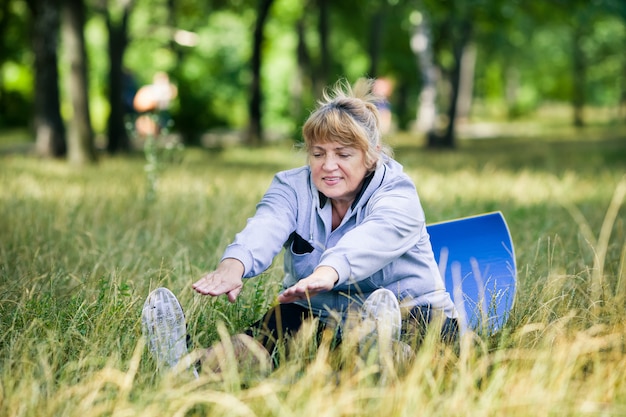 Senior woman doing yoga in the park