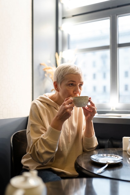 Senior woman drinking coffee with friends