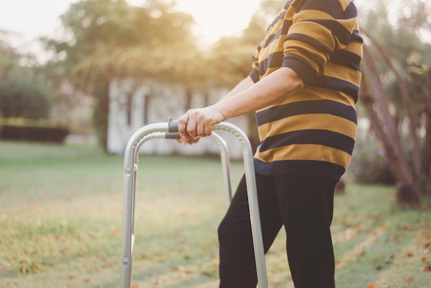 Senior woman hands holding walker trying to walk at nature Physical therapy concept