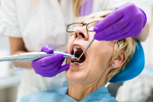 Senior woman having dental treatment at dentist's office.