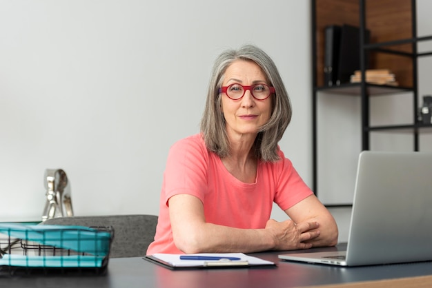 Senior woman at home studying on laptop