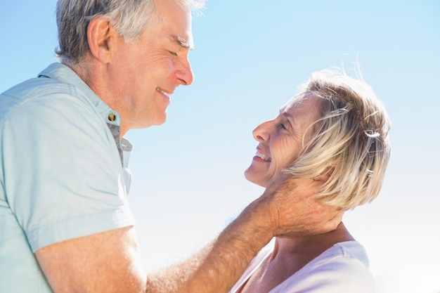 Senior woman hugging her partner on a sunny day