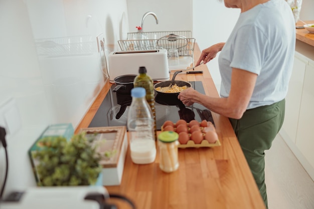 Senior woman is preparing meal in kitchen