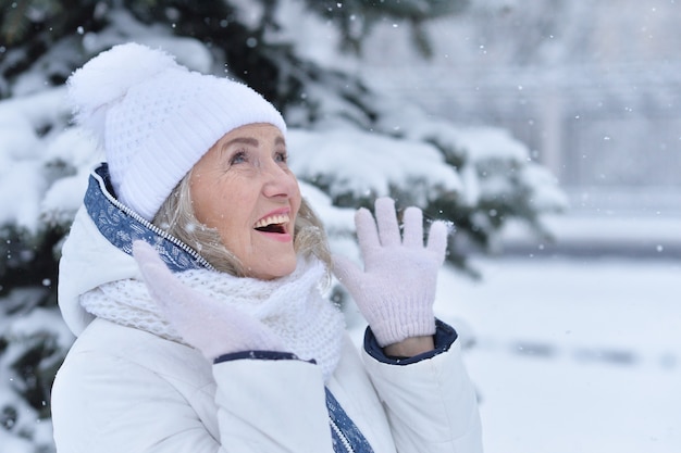 Senior woman laughing and rejoice in snowy winter