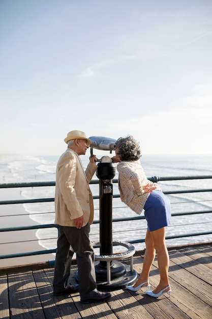 Senior woman looking through a telescope while being on a date