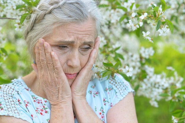 Senior woman near blooming tree