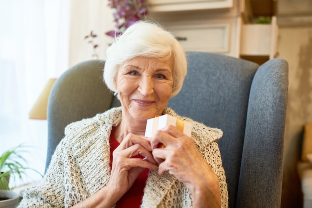 Senior woman opening a gift