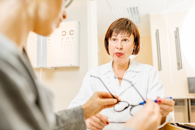 Senior woman ophthalmologist with young female patient during the consultation in the ophthalmological office