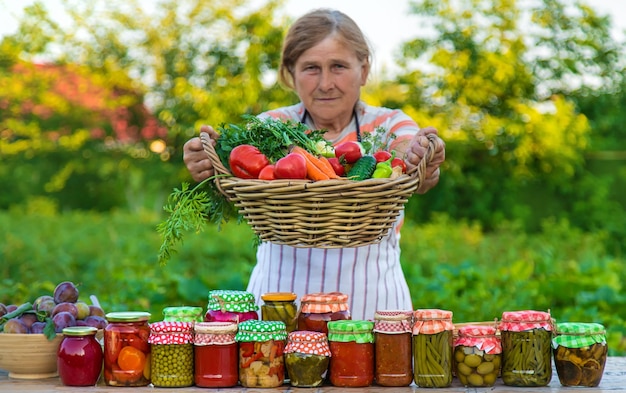 Senior woman preserving vegetables in jars Selective focus