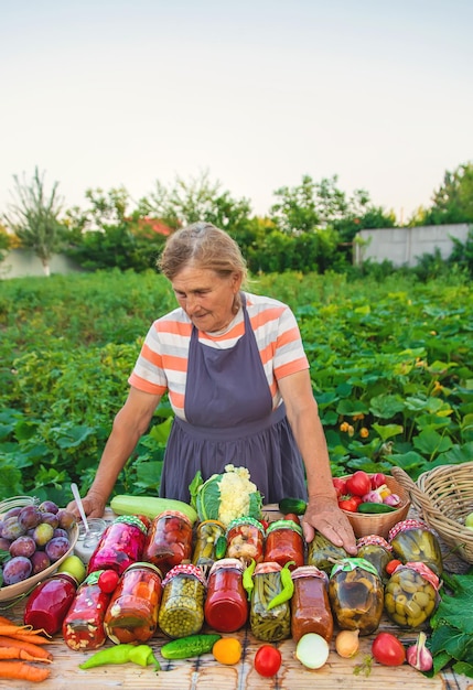 Senior woman preserving vegetables in jars Selective focus