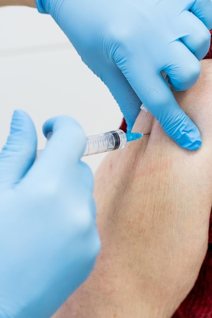 Senior woman receiving vaccinemedical worker vaccinating an elderly patient against fluinfluenzapneu