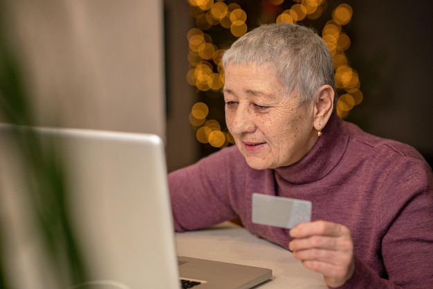 A senior woman sitting in front of a laptop communicates online through social networks.