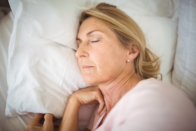 Senior woman sleeping on bed