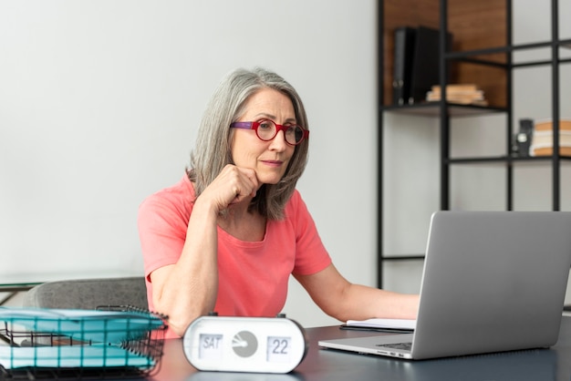 Senior woman studying at home while using laptop